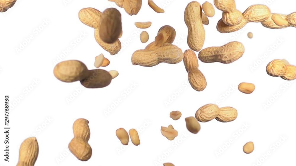 unpeeled and peeled peanuts flying in slow motion on white background unpeeled and peeled peanuts flying in slow motion on white background