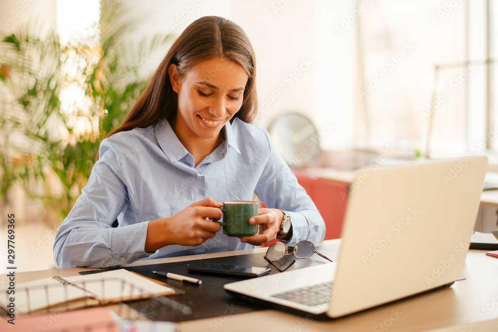 Young businesswoman drinking coffee in her office Young businesswoman drinking coffee in her office