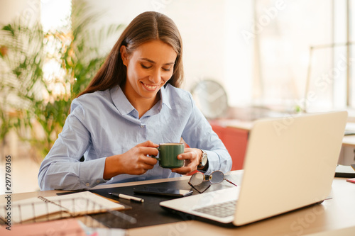 Young businesswoman drinking coffee in her office	