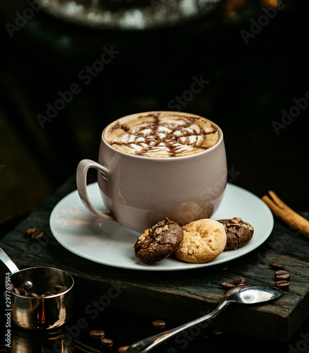 glass of macchiato with chocoloate and milk cookies, in dark background photo