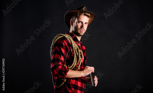 adventure lover. Vintage style man. Wild West retro cowboy. wild west rodeo. man in hat black background. man checkered shirt on ranch. cowboy with lasso rope. Western. western cowboy portrait