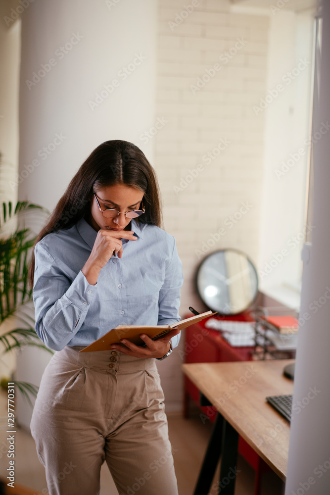 Young businesswoman with glasses taking notes Young businesswoman with glasses taking notes