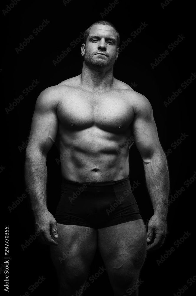 sports man standing on a black background, doing sports. sports man standing on a black background, doing sports.