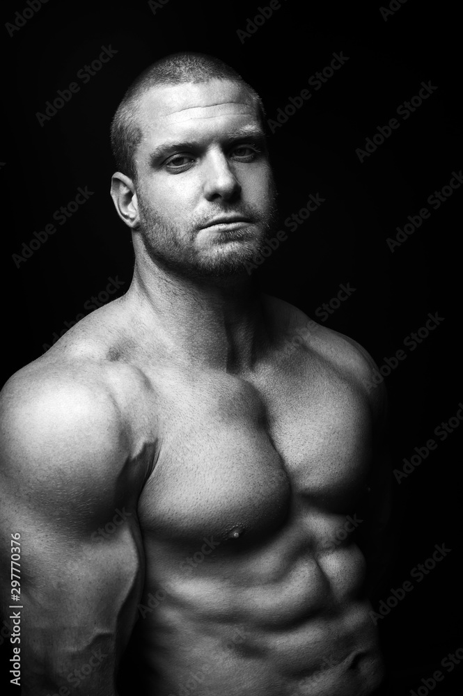 Fototapeta premium sports man standing on a black background, doing sports.