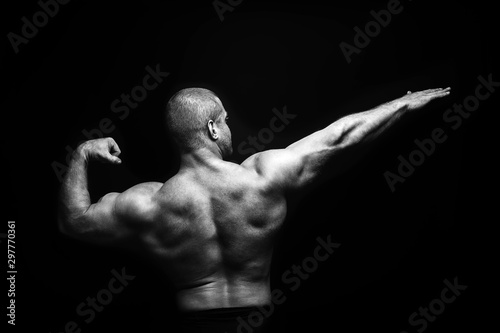sports man standing on a black background, doing sports. © Evgeny Leontiev