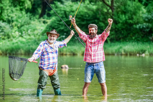 Fisherman with fishing rod. Activity and hobby. Fishing freshwater lake pond river. Bearded men catching fish. Master baiter. Mature man with friend fishing. Summer vacation. Happy cheerful people