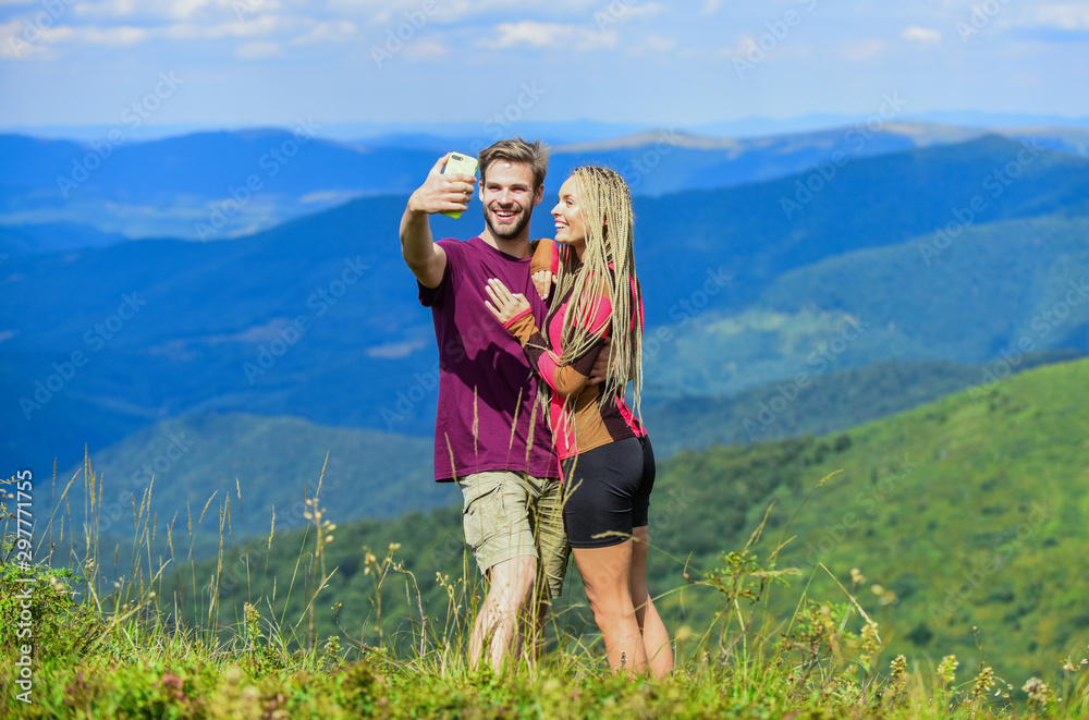 Couple taking photo. Summer vacation concept. Young adventurers. Travel together with darling. Couple in love hiking mountains. Lets take photo. Capturing beauty. Man and woman posing mobile photo