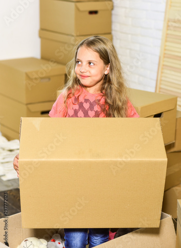 happy child cardboard box. playing into new home. new apartment. happy little girl. Cardboard boxes - moving to new house. purchase of new habitation. girl hold huge box © be free