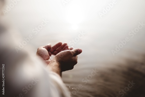 Fototapet High angle shot of Jesus Christ holding water with his palms