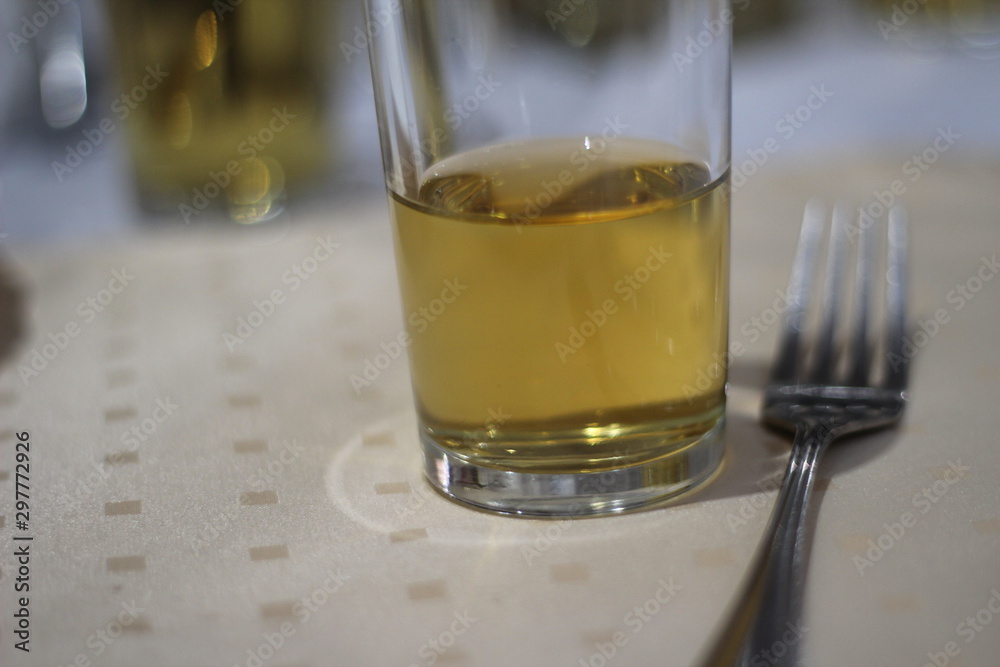 a glass of juice next to a fork a glass of juice next to a fork