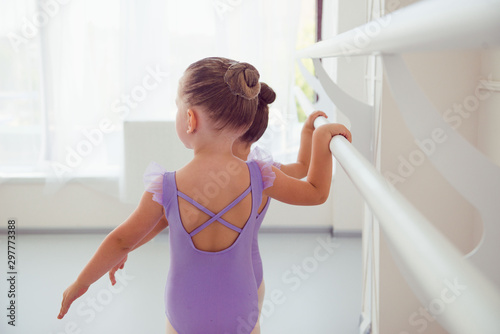 little girls in lilac training suit doing exersice in ballet class photo