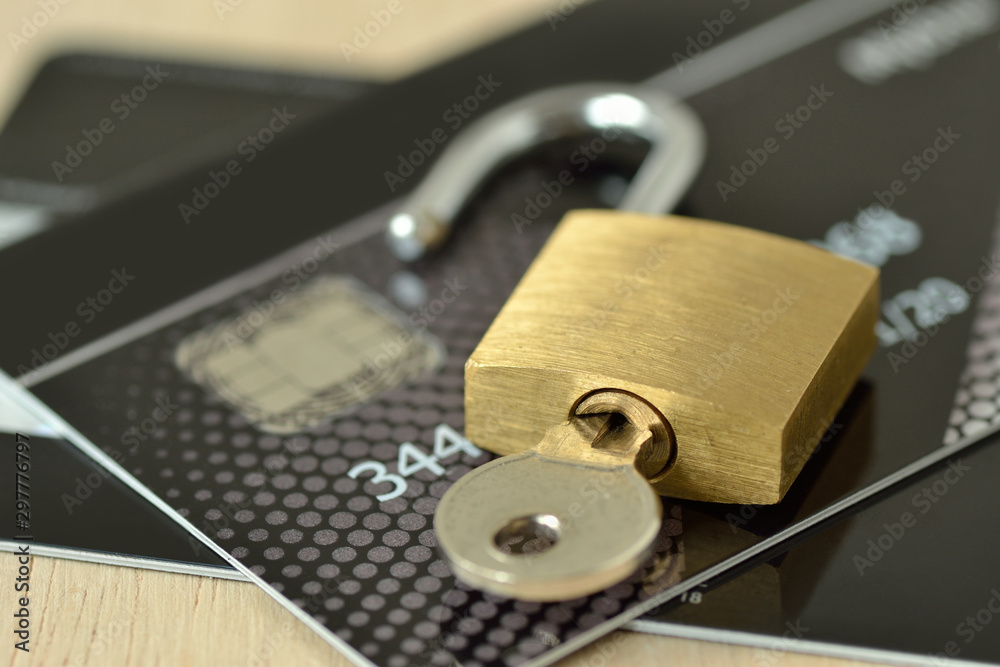 Unlocked padlock with key on credit card - Concept of security and protected paying Unlocked padlock with key on credit card - Concept of security and protected paying