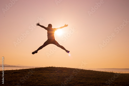 silhouette of Jumping Man on the peaks and backgrounds of sunrise or sunset,men trail running, the sky at sunrise running in the mountains, lifestyle
