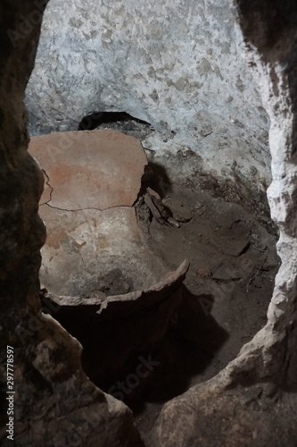 Curious hole in the cave with ruins ancient objects