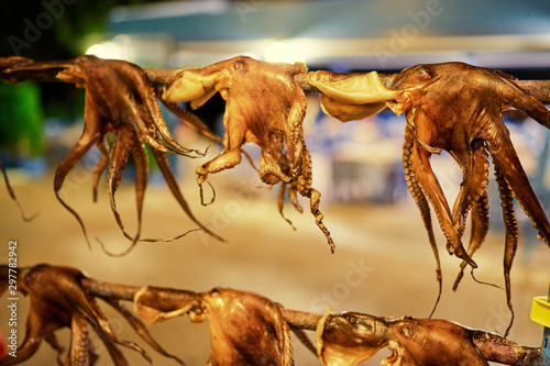 Fototapeta Naklejka Na Ścianę i Meble -  Octopus tentacles dried in a Greek tavern on the street in Greece.
