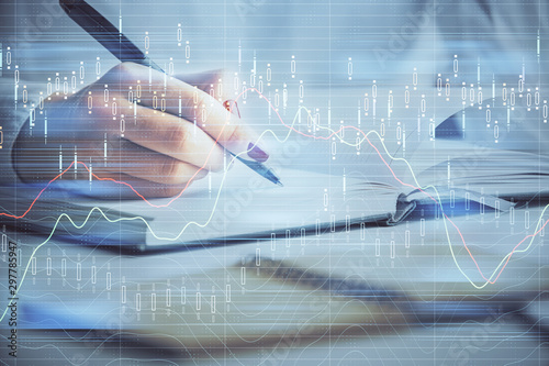 Multi exposure of woman's hands making notes with forex graph hologram. Concept stock market analysis.