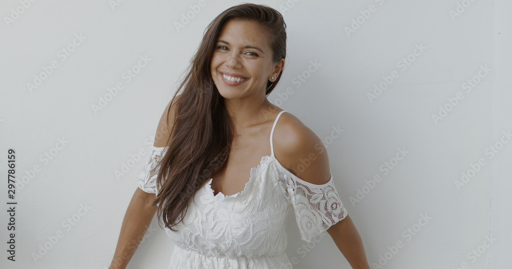 Happy young woman in white dress looking at camera - obrazy, fototapety, plakaty 