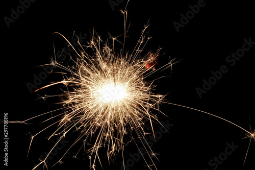 Closeup view of bright burning sparkler on a black background