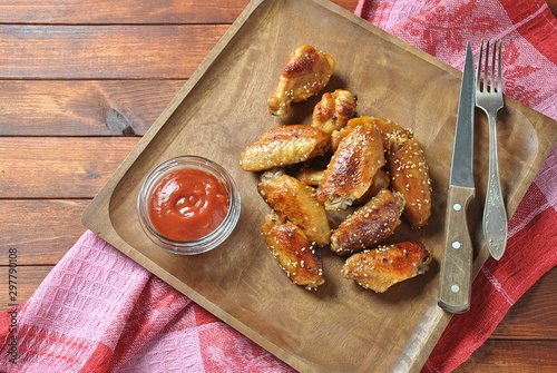 Grilled, barbecue chicken wings, tasty food for dinner or lunch. Fried chicken wings with sesame seeds. Fast food concept photo