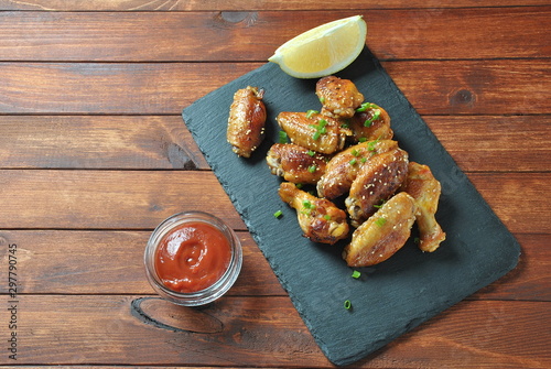 Grilled, barbecue chicken wings, tasty food for dinner or lunch. Fried chicken wings with sesame seeds. Fast food concept photo