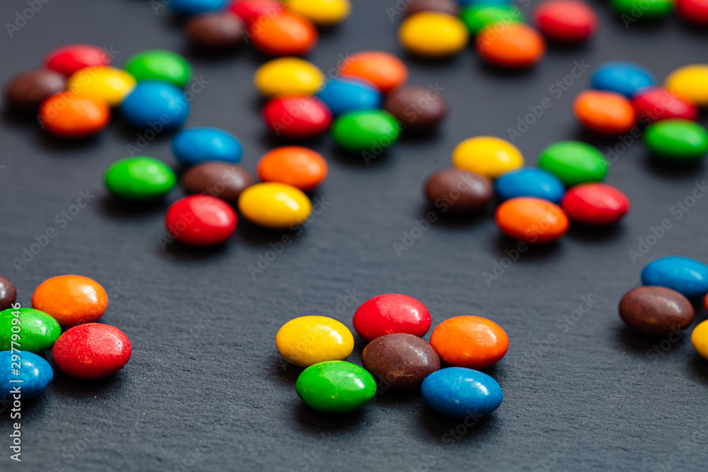 colorful chocolate buttons isolated on a black background colorful chocolate buttons isolated on a black background