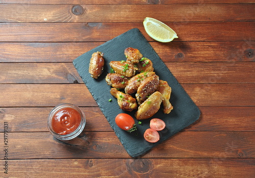 Grilled, barbecue chicken wings, tasty food for dinner or lunch. Fried chicken wings with sesame seeds. Fast food concept photo