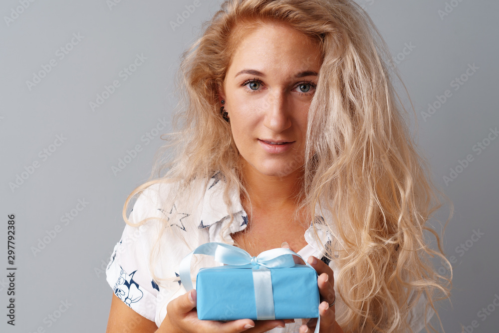 Nice woman holding a blue gift box in her hands Nice woman holding a blue gift box in her hands