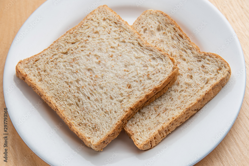 Sliced bread on white dish, wood background