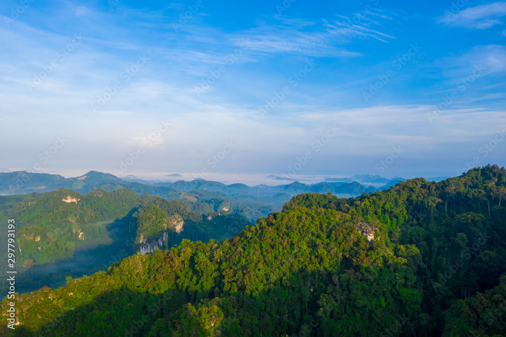 Aerial view of mountains with cloud cover mountain at sunrise and blue sky in Surat Thani Province, Thailand.