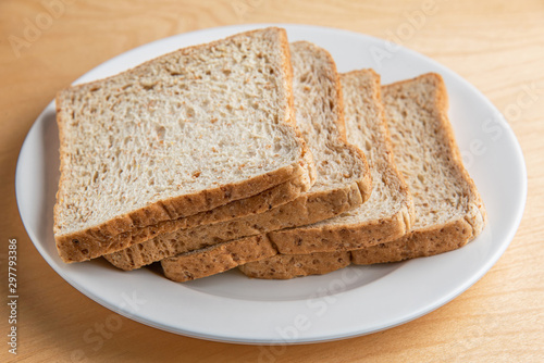 Sliced bread on white dish, wood background