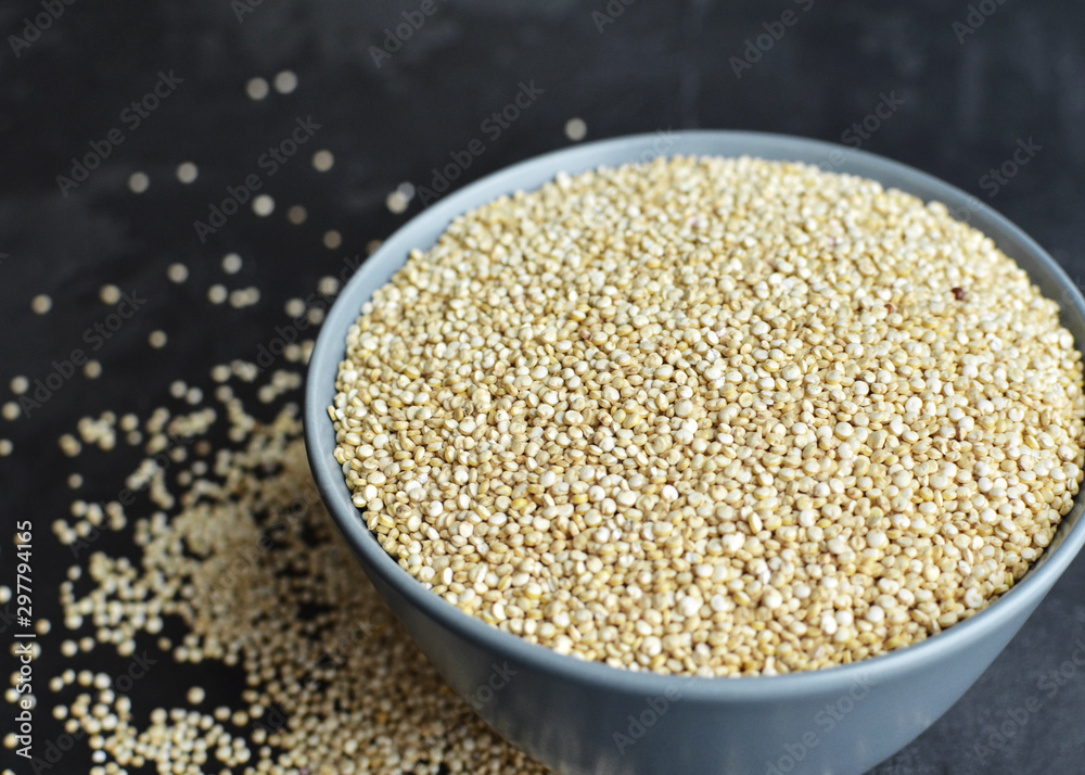 Pile of quinoa grain seeds in bowl over dark stone table background Pile of quinoa grain seeds in bowl over dark stone table background