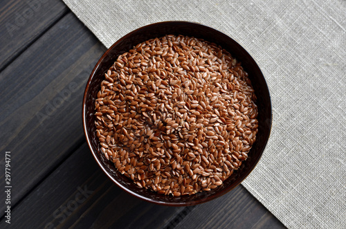 flax seeds in bowl on linen fabric background