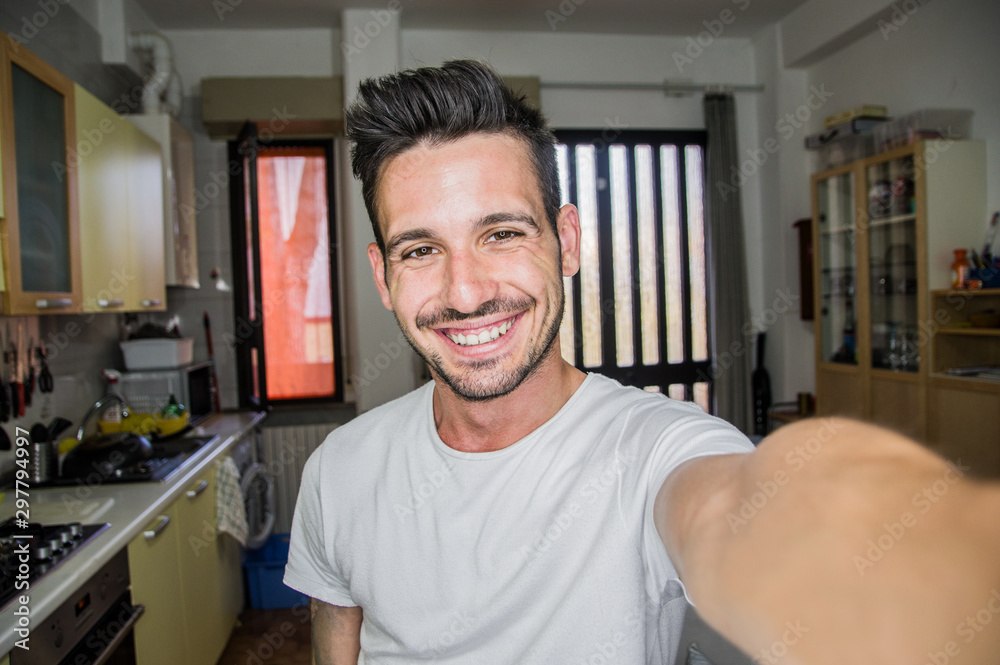 Photo of handsome man taking a selfie at home smiling on the camera - obrazy, fototapety, plakaty 