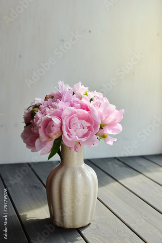 Bouquet of pink peony flowers over wooden window sill background