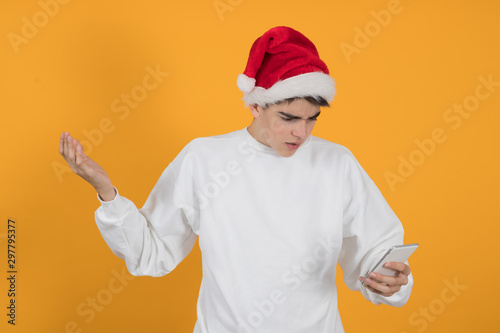 young teenage man with santa claus hat isolated on color background