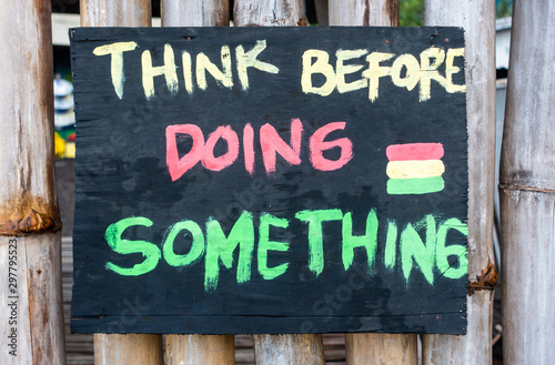 Handmade painted sign reads think before doing something