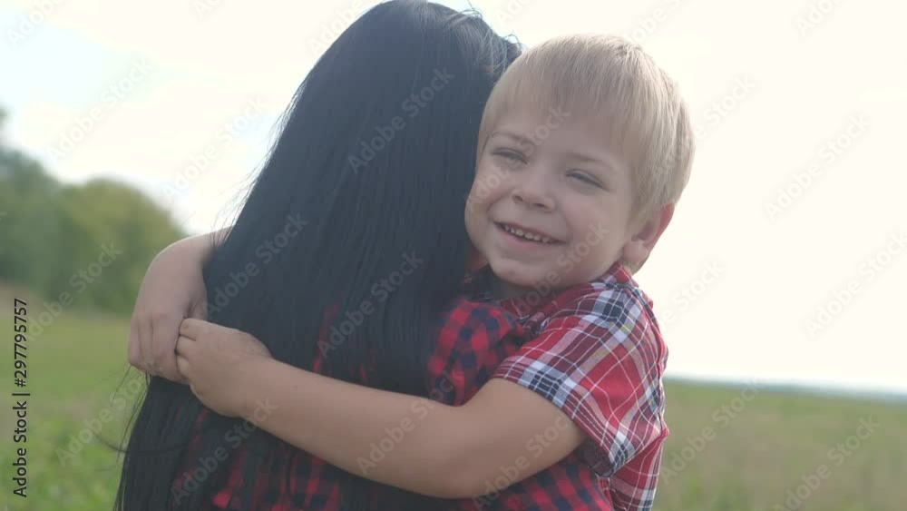 happy family. mom and son happiness love teamwork concept. gentle touching slow motion video. son little boy hugs mom girls outdoors. lifestyle happy family blond a boy and mom brunette happy family. mom and son happiness love teamwork concept. gentle touching slow motion video. son little boy hugs mom girls outdoors. lifestyle happy family blond a boy and mom brunette