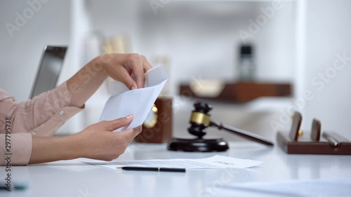 Divorced woman holding envelope with alimony, savings for single mom, allowance photo