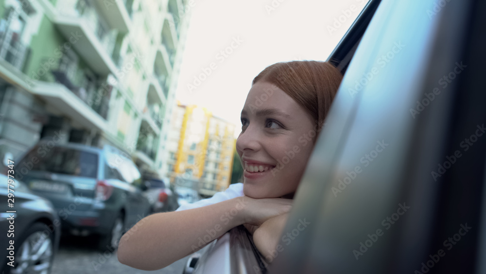 Happy girl looking through window, enjoying city attractions travelling by car Happy girl looking through window, enjoying city attractions travelling by car