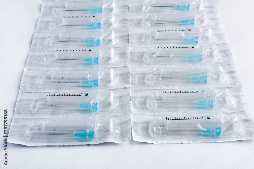 Syringes with covered needles isolated on white background