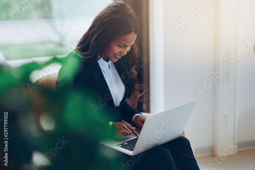 Smiling African American businesswoman using a laptop in an offi photo