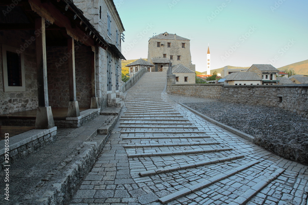 The uneven surface of the walkway accross the Old Bridge (Stari Most) at sunrise, with medieval buildings, Mostar, Bosnia and Herzegovina