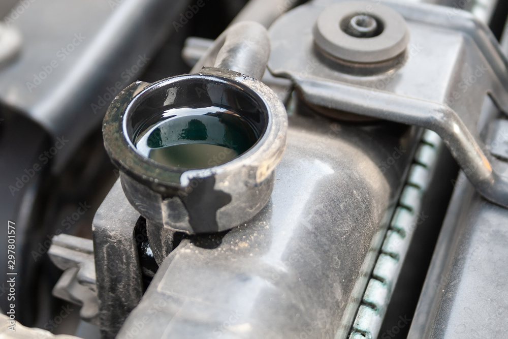 Antifreeze in the radiator. Closeup detail of a Flat-four (boxer) car engine compartment under the open hood Antifreeze in the radiator. Closeup detail of a Flat-four (boxer) car engine compartment under the open hood