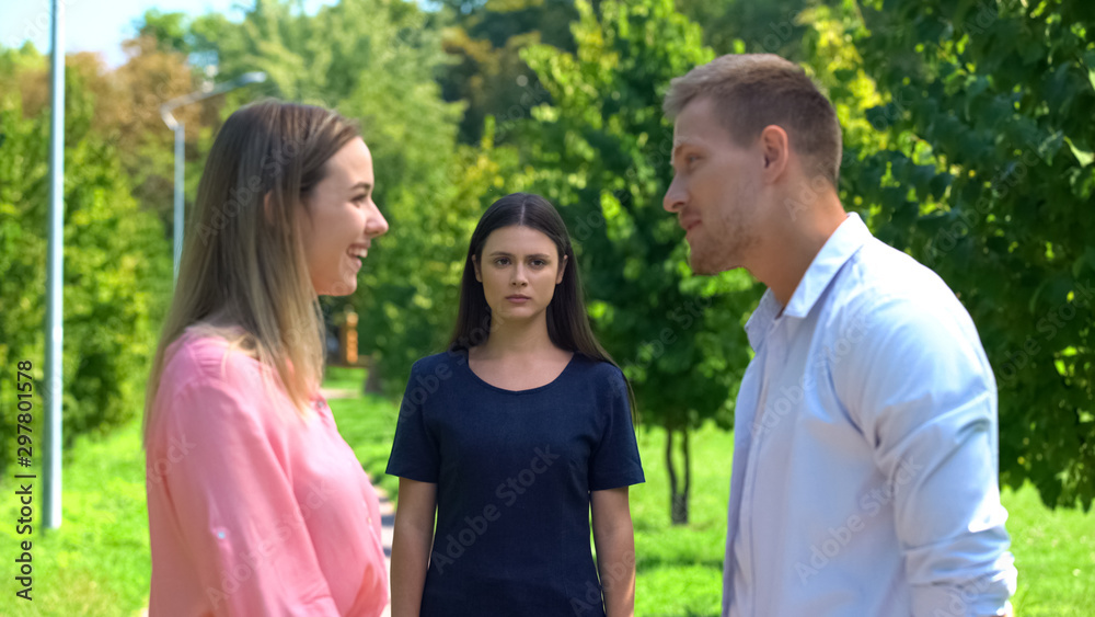 Offended female feeling lonely looking at friend talking boyfriend, jealousy Offended female feeling lonely looking at friend talking boyfriend, jealousy