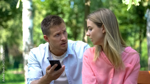 Jealous husband shouting at wife looking through messages on phone, breakup © motortion