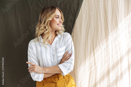 фотографія Image of caucasian elegant blonde woman standing with arms crossed