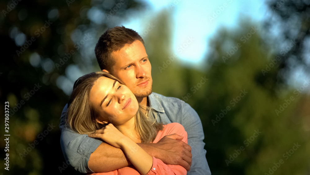 Hugging couple in park, tender relations, boyfriend and girlfriend romantic date