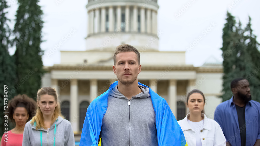People covered in Ukrainian flag protesting against corruption in country People covered in Ukrainian flag protesting against corruption in country