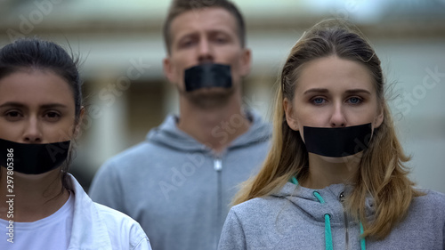 Crowd demonstrating with taped mouth, march of silence against police brutality photo