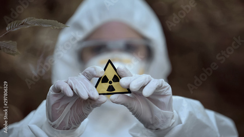 Radiation sign scientist hands, exclusion zone, disaster area, ecological crisis photo